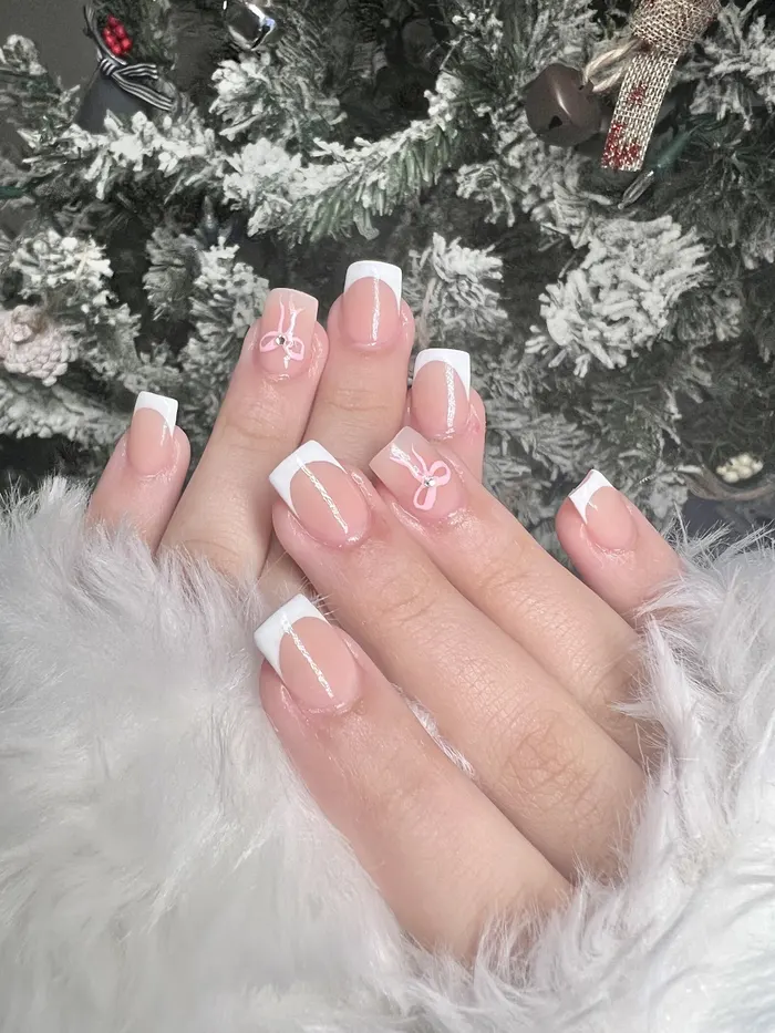 Short French tips with a bow accent